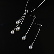un collier de perles blanches avec des boucles d'oreilles chaîne en argent correspondant